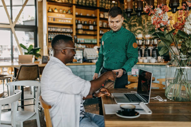 istock Young man sitting in coffee shop and working 1277105773