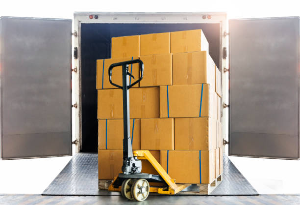 istock Shipment goods, Cargo freight truck, Delivery. Hand pallet jack with stack cardboard boxes on pallet loading into container truck. Logistics and transportation. 1277105868