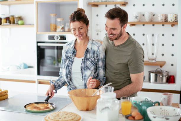 istock Young couple making pancakes at home. 1277106246