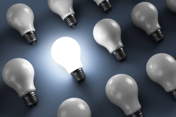 istock A group of light bulbs on the table. One of them glows. 1277107273
