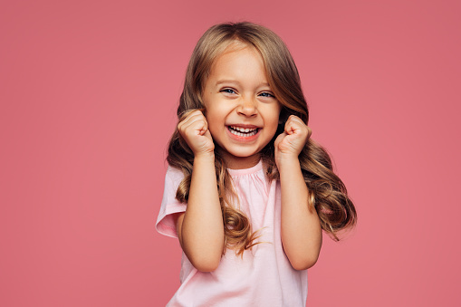 Nice little girl look camera. Crazy naughty bad child head shot. Funny small kid have fun. Silly cute face close up. Young pretty person posing. One joyful pupil fool around. Happy childhood concept.