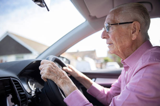 worried senior male driver looking through car windscreen - conduzir imagens e fotografias de stock
