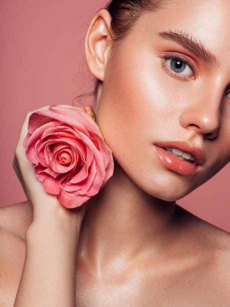 Beautiful woman with pink rose Beautiful woman with pink rose stage makeup women beauty human face stock pictures, royalty-free photos & images