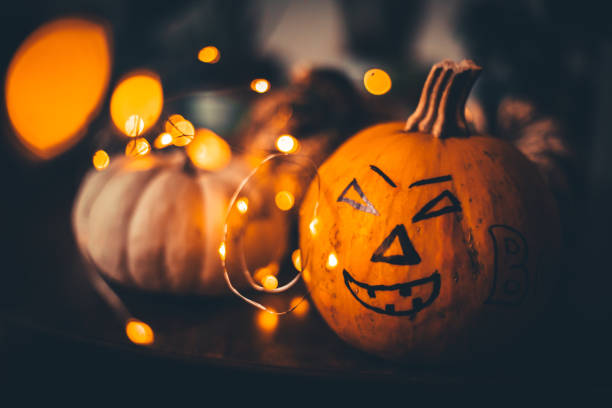 istock Halloween - Jack O' Lanterns - String Lights On Wooden Table 1277113431