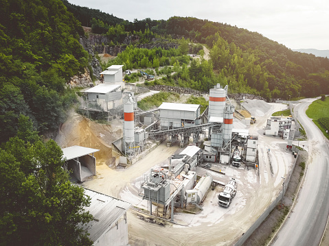 Aerial photo of working stone quarry in Slovenia country side. Machines and trucks  on site for gravel transport.