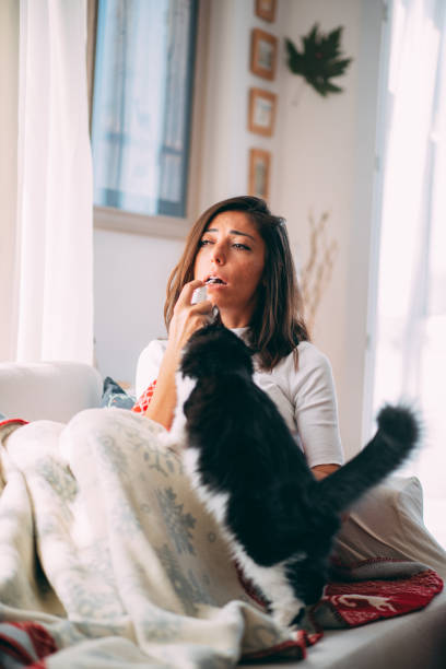 istock Sick Woman is Lying on the Sofa With Her Cat 1277116623