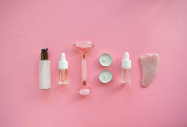istock Massage with a quartz roller for the face with pink natural jade. Gouache massage tool, with beauty serum oil. Anti-aging and lifting at home. Facial care massage and relaxation concept. 1277118080