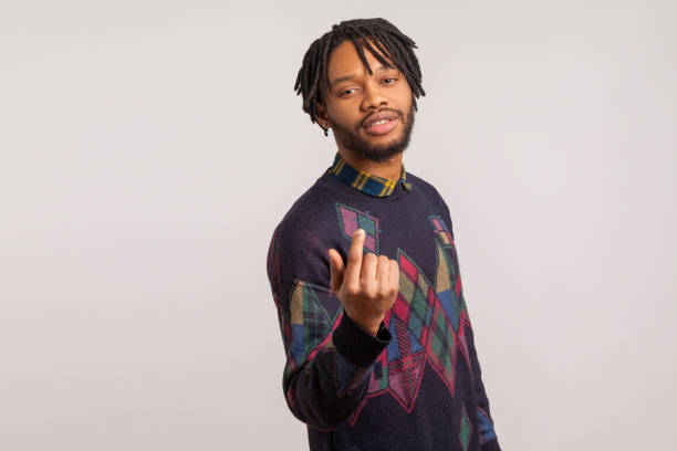 istock Come here. Handsome bearded african man with dreadlocks in casual style sweatshirt calling you looking at camera and showing finger, flirting 1277118447