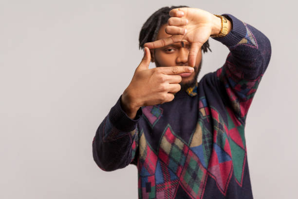istock Serious african man with dreadlocks looking through fingers making camera gesture, camera men looking for properly focus, capturing moments 1277118457