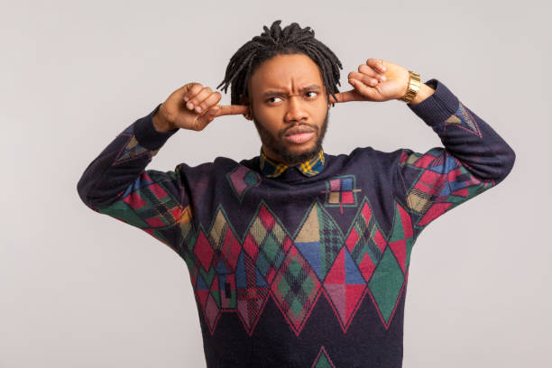 I dont want to hear this. Annoyed frustrated african guy with dreadlocks closing ears with fingers ignoring information, tired of irritating noise I dont want to hear this. Annoyed frustrated african guy with dreadlocks closing ears with fingers ignoring information, tired of irritating noise. Indoor studio shot isolated on gray background man closing ears photos stock pictures, royalty-free photos & images