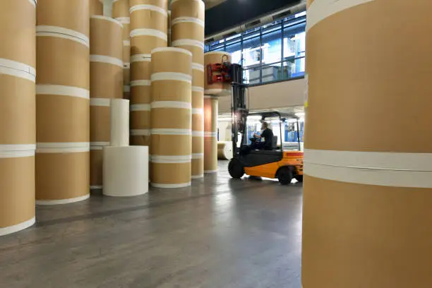 Photo of Storage of paper rolls in a large print shop - transport with a forklift truck
