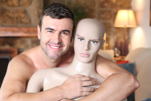 Handsome man hugging a mannequin Handsome man hugging a mannequin. blow up doll stock pictures, royalty-free photos & images
