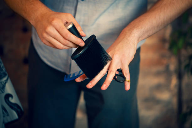 Close up of hands holding neck duster hair brush. stock photo