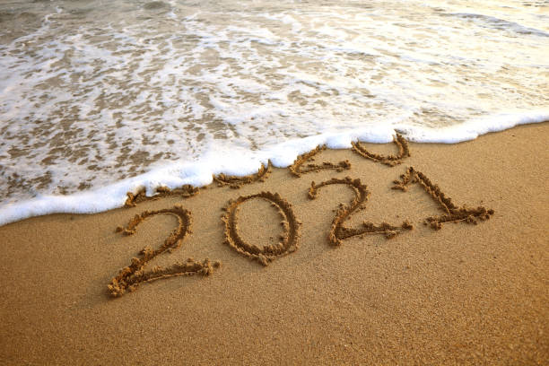 istock New year 2021 and 2020 on sandy beach with waves 1277125328