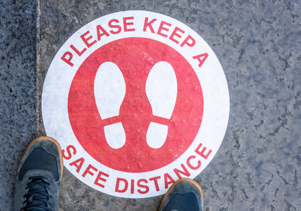 istock Standing at a social distancing guidance sign 1277126900