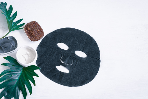 Spa composition with face care items with a black mask on a white background. Modern concept of Spa and beauty products.