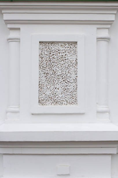 Decor on the wall of an old stone building, semi-columns and a panel with decorative plaster.
