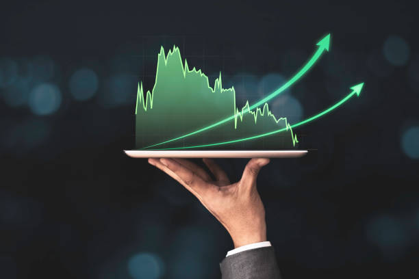istock Businessman holding mobile & tablet which showing green technical stock investment graph with increase arrow. Value investor and analysis data concept. 1277132465