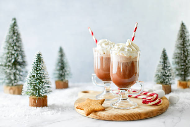 heiße schokolade oder kaffee mit schlagsahne serviert mit einem zuckerrohr, marshmallows und lebkuchenstern - christmas desserts stock-fotos und bilder