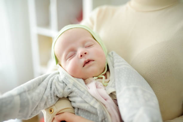Newborn baby girl in her mother arms. Baby sleep quietly witout pacifier Newborn baby girl in her mother arms. Newborn baby girl in her mother arms. Baby sleep quietly without pacifier. Warm clothes for the baby in the autumn or winter season. witout stock pictures, royalty-free photos & images