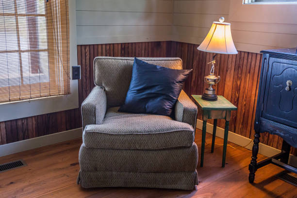 A bright blue color backrest pillow on cozy style chair and table set without people. Interior decoration object, close-up photo.