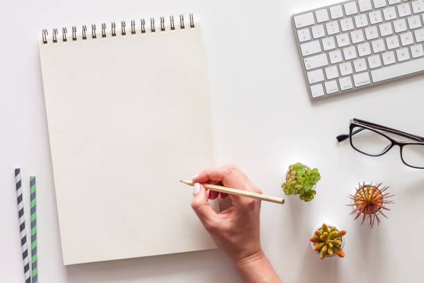 istock Sketchbook mockup. Female hand with a pencil. 1277133939