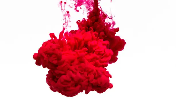 Squeezing the red paint into the water.  Red ink in water isolated on white background