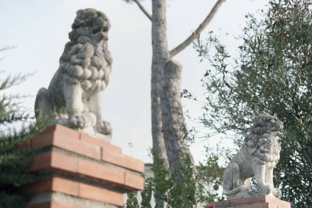 two statues of lions guard a villa