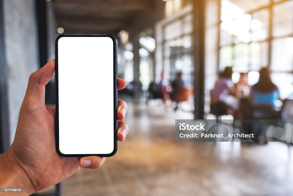 ein Mann hält schwarzes Handy mit leerem weißen Bildschirm im Café - Lizenzfrei Ausrüstung und Geräte Stock-Foto