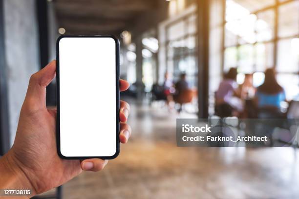 Ein Mann Hält Schwarzes Handy Mit Leerem Weißen Bildschirm Im Café Stockfoto und mehr Bilder von Ausrüstung und Geräte
