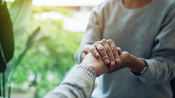 istock Women holding each other hands for comfort 1277138158