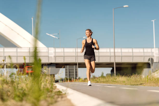 istock Young happy sportswoman jogging outdoors during a day. 1277138514