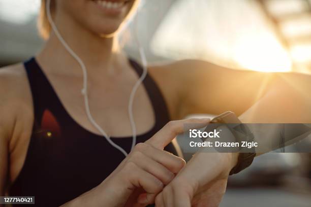 Closeup Of Athletic Woman Using Fitness Tracker At Sunset Stock Photo - Download Image Now