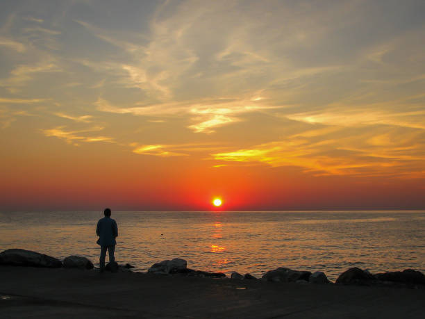 istock man on the seashore looks at dawn 1277141523