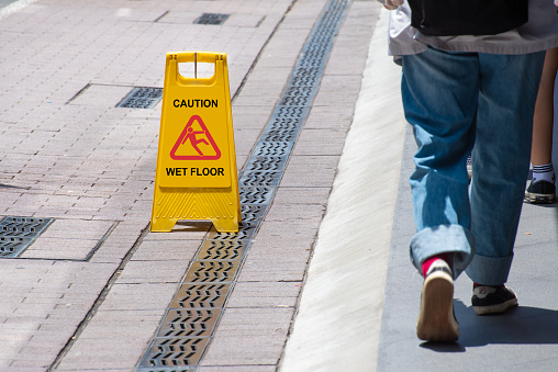 Yellow Caution Wet Floor Sign on pedestrian walkway