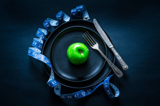 gesundes ernährungskonzept - healthy eating fork tape measure still life stock-fotos und bilder