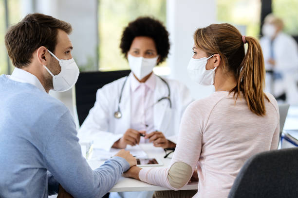 istock Couple holding hands while consultations at doctor's office during coronavirus epidemic. 1277146624