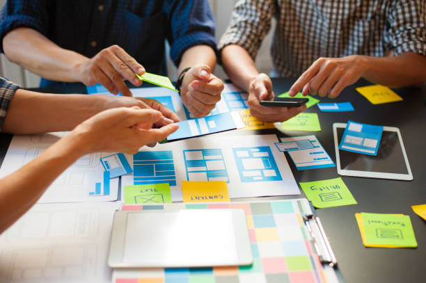 istock Group of web designers brainstorming work to design mobile apps. 1277148310