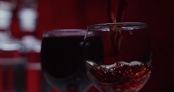 Red wine on the red background. Close-up