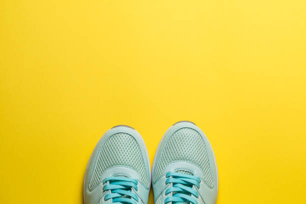 istock Turquoise sneakers with white soles on a yellow background close-up 1277150162