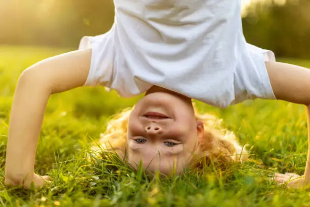 Photo of Little boy standing upside down in park