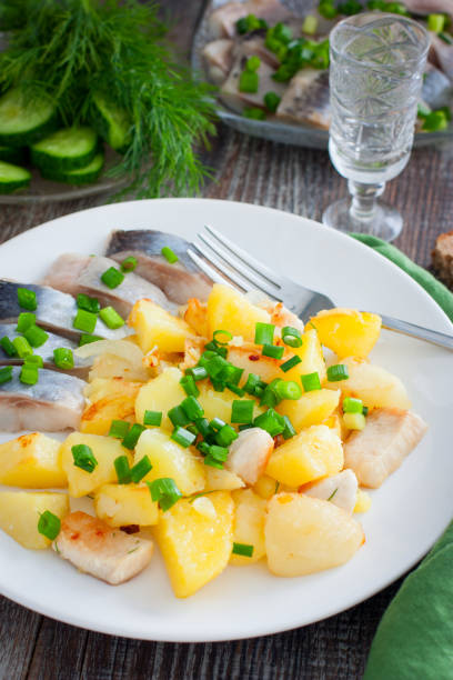 istock fried potatoes with chicken fillet on a white plate with salted herring pieces, selective focus 1277152475