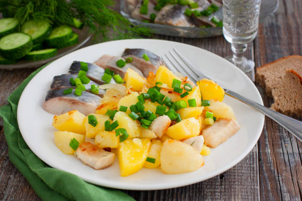 istock fried potatoes with chicken fillet on a white plate with salted herring pieces, selective focus 1277152476