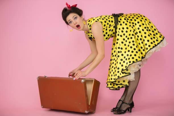 belle pin-up fille ouvre une valise rétro. femme rétro dans la robe jaune de point de polka. l’émotion de la surprise. - polka dot suitcase retro revival women photos et images de collection
