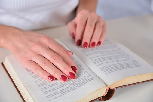 Girl Hand With Red Manicure On Nails Finger On Open Book Stock Photo ...