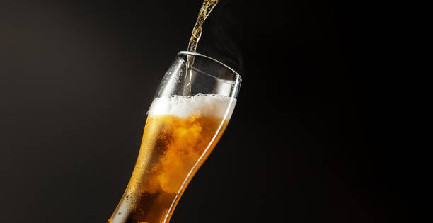 gieten van koud en verfrissend bier in glas met schuim, horizontale flyer - bel vloeistof fotos stockfoto's en -beelden