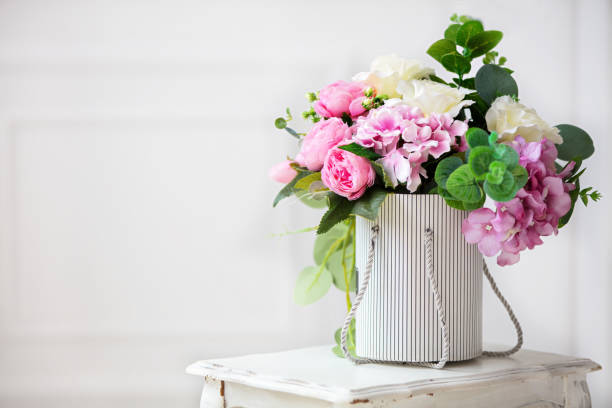 belles pivoines dans une boîte en papier sur un fond blanc. - flower arrangement photos photos et images de collection