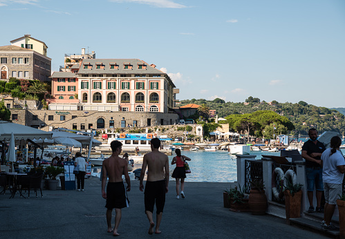 Portovenere, Liguria, Italy. June 2020. View of the promenade in front of the beautiful houses with colorful facades: people walking along seaside.