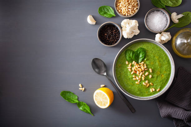 зеленый сливочный суп из шпината из цветной капусты на сером фоне - healthy eating close up lemon nut стоковые фото и изображения