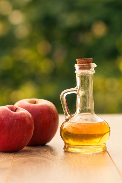 istock Apple cider vinegar in glass bottle and fresh red apple in blurred background 1277163154
